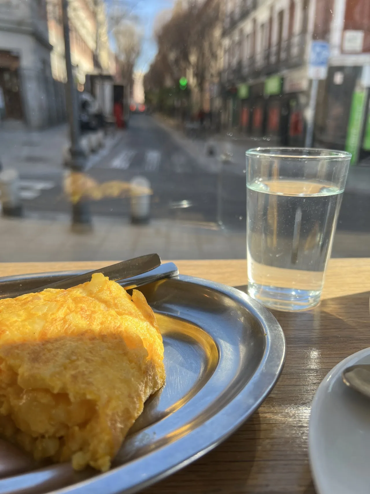 A wedge of Spanish tortilla on a metal plate