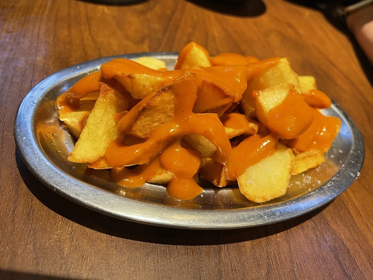 A plate of fried potatoes topped with spicy brava sauce