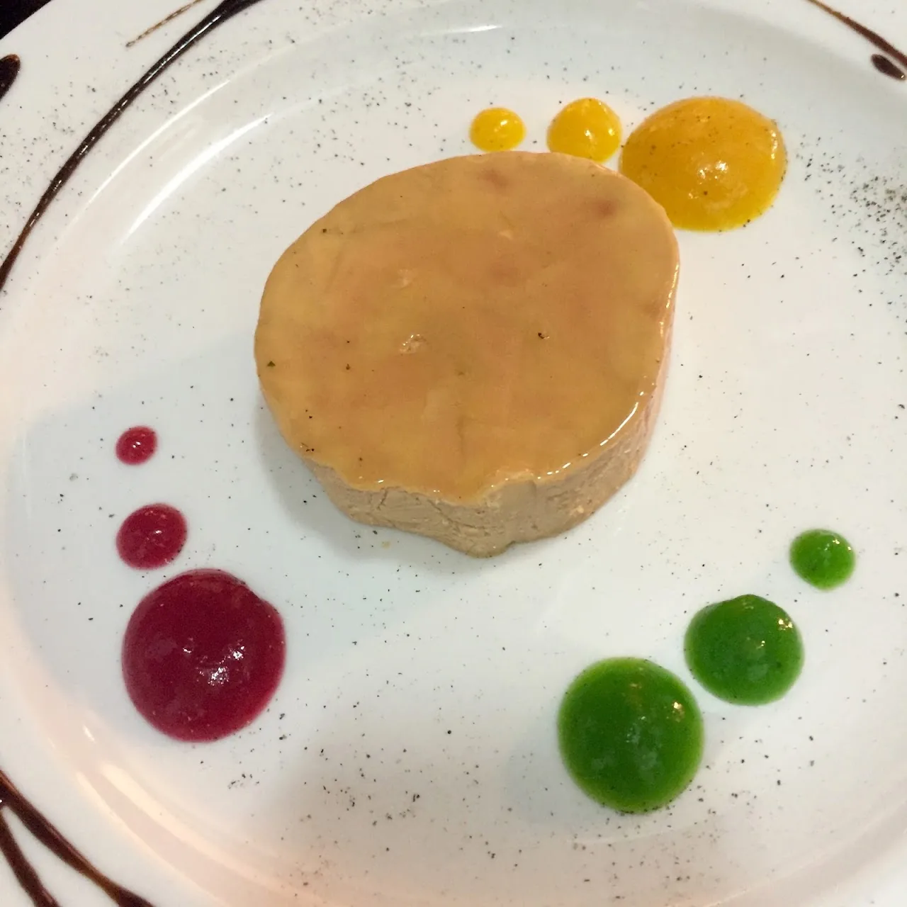 A foie terrine with dots of fruit gel and citrus segments