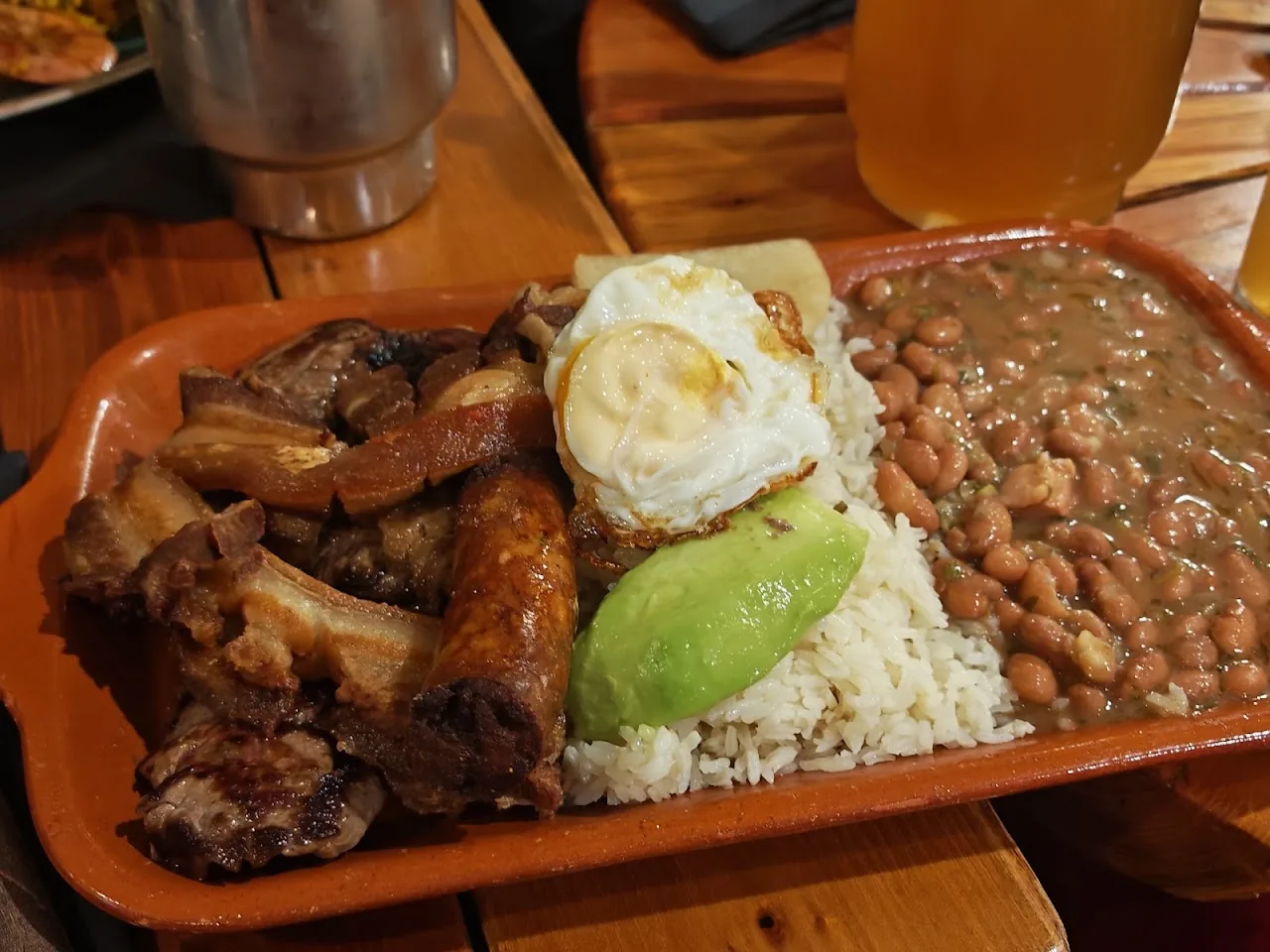 A tray of grilled ribs, fried egg, rice, and avocado