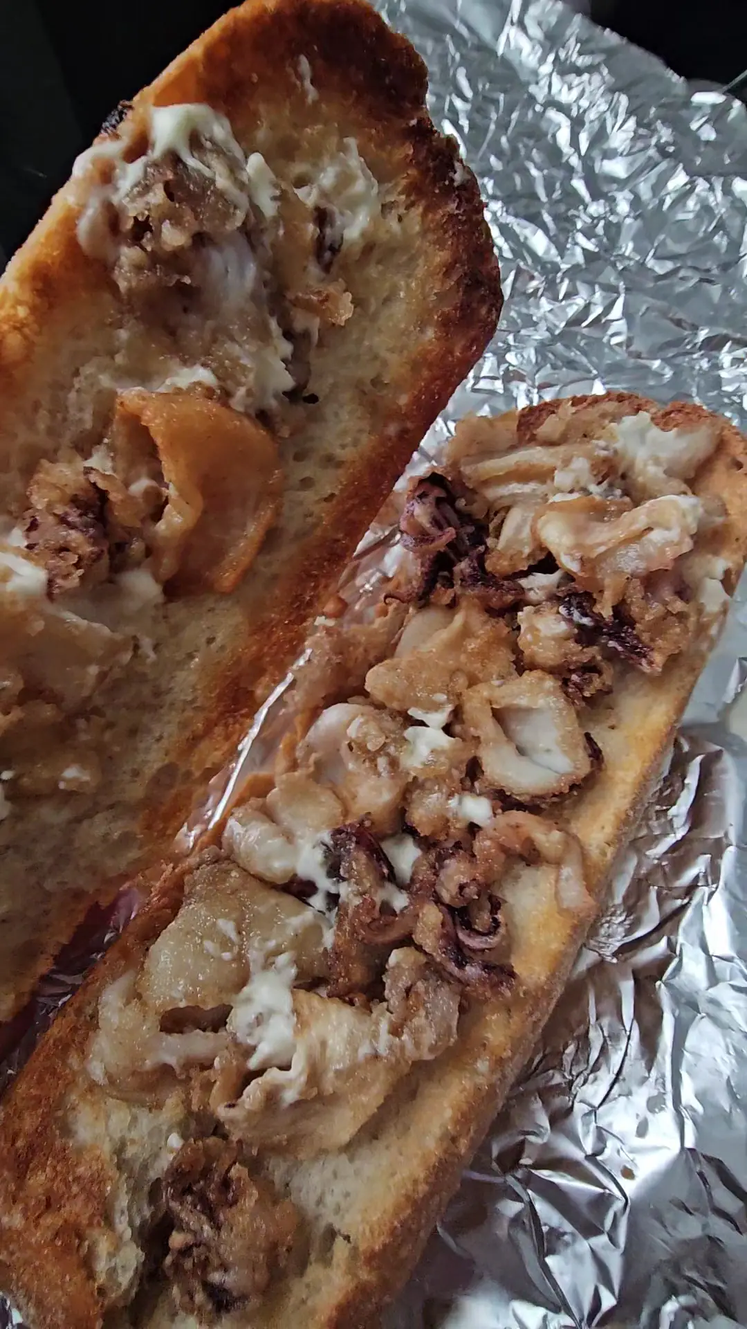 An open baguette with a savoury filling, served on foil