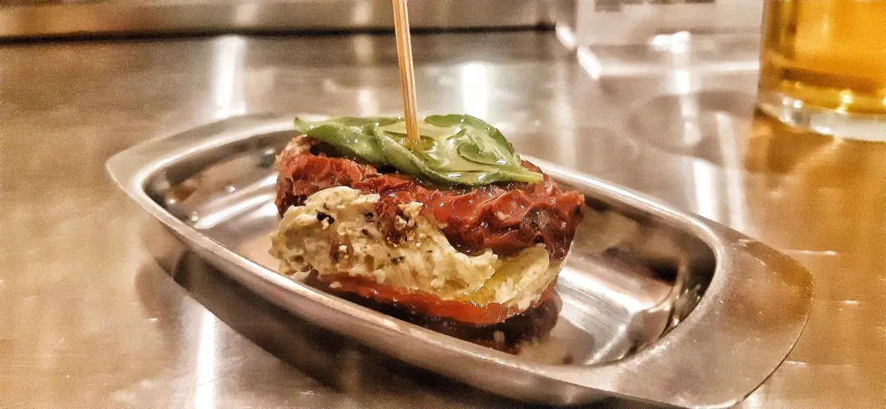 Skewered pincho of roasted red pepper, cheese and basil served on a small tray