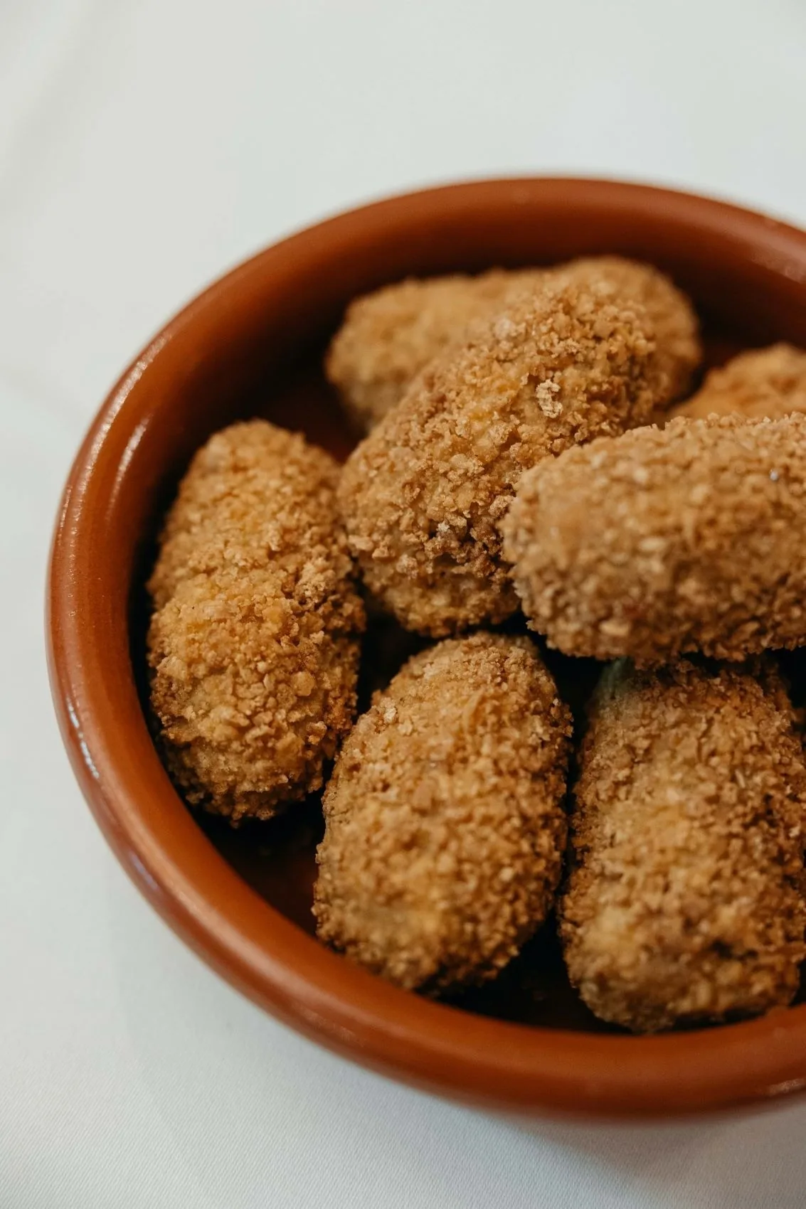 Breaded croquettes in a terracotta dish