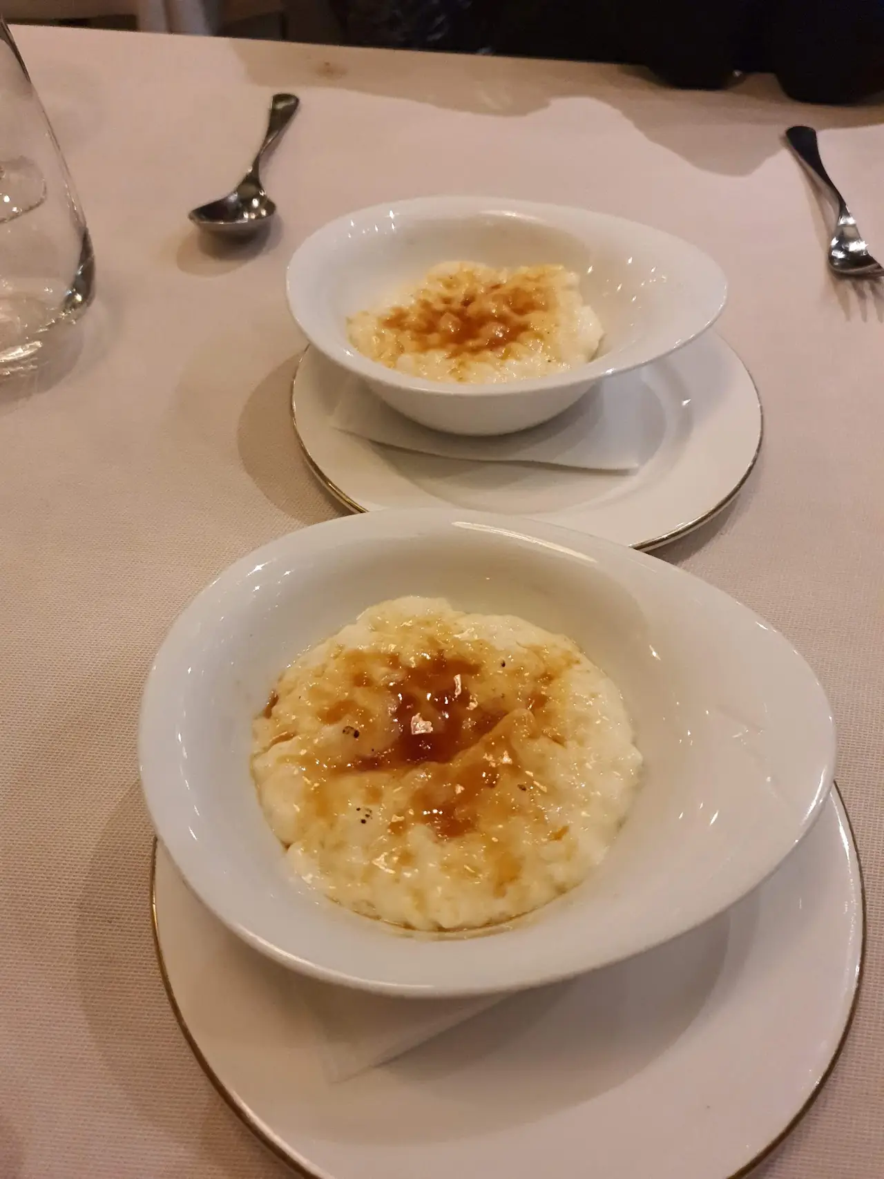 Two small bowls of creamy rice pudding with a caramelized topping
