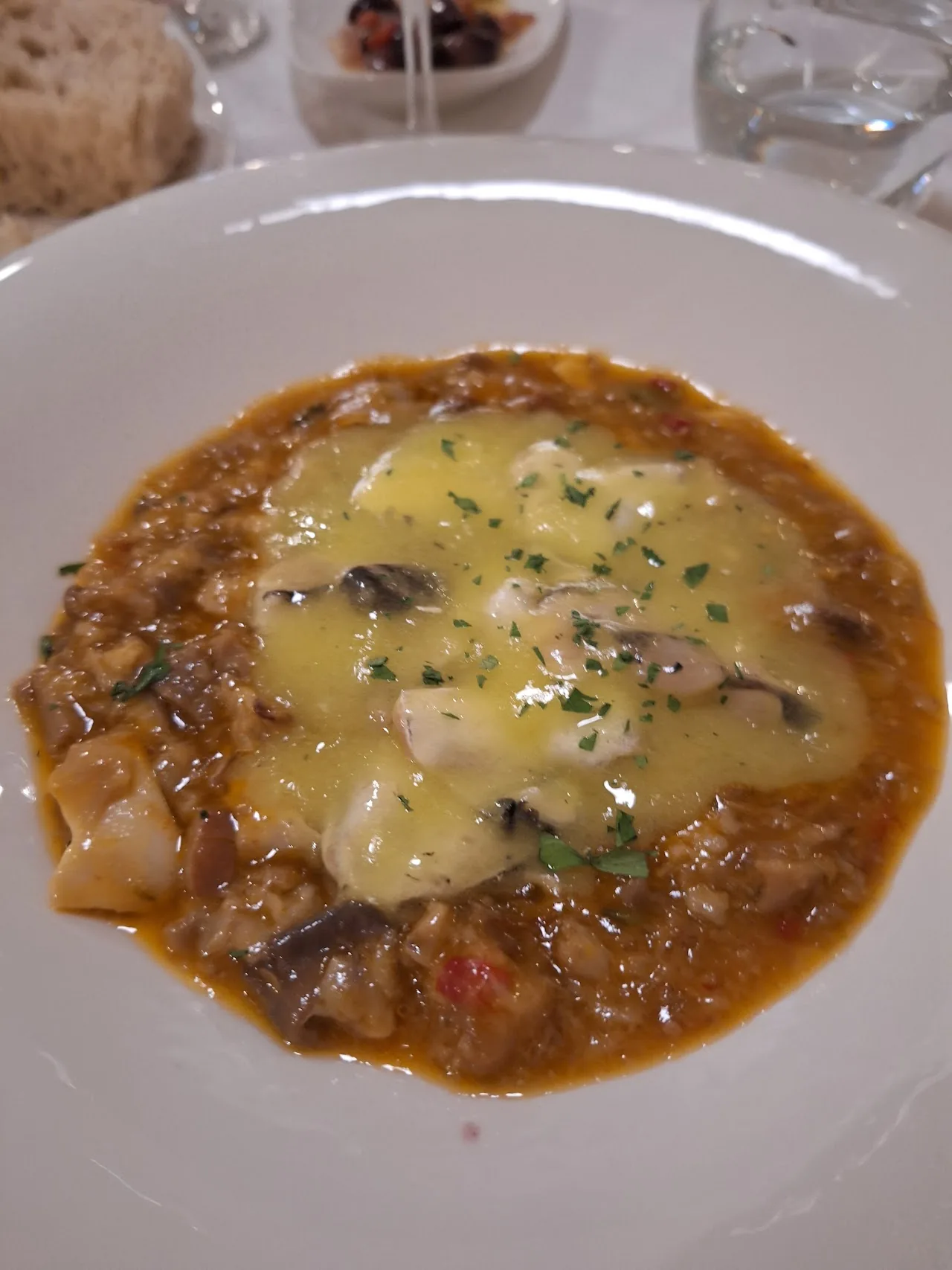 A mushroom and meat stew topped with melted cheese