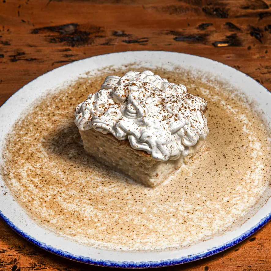 A white plate with a creamy dessert dusted with cinnamon