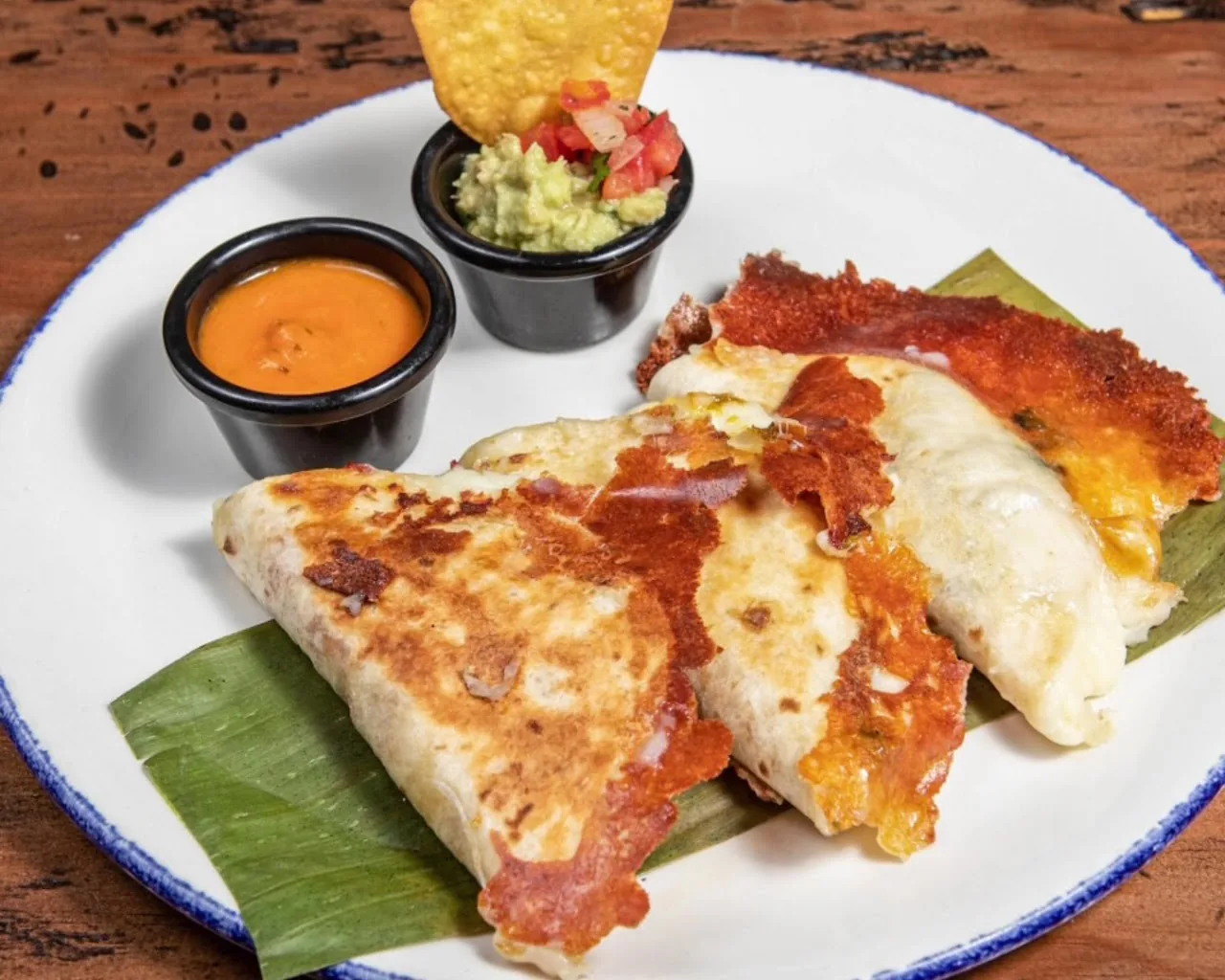 Folded quesadillas with melted cheese and dipping sauces