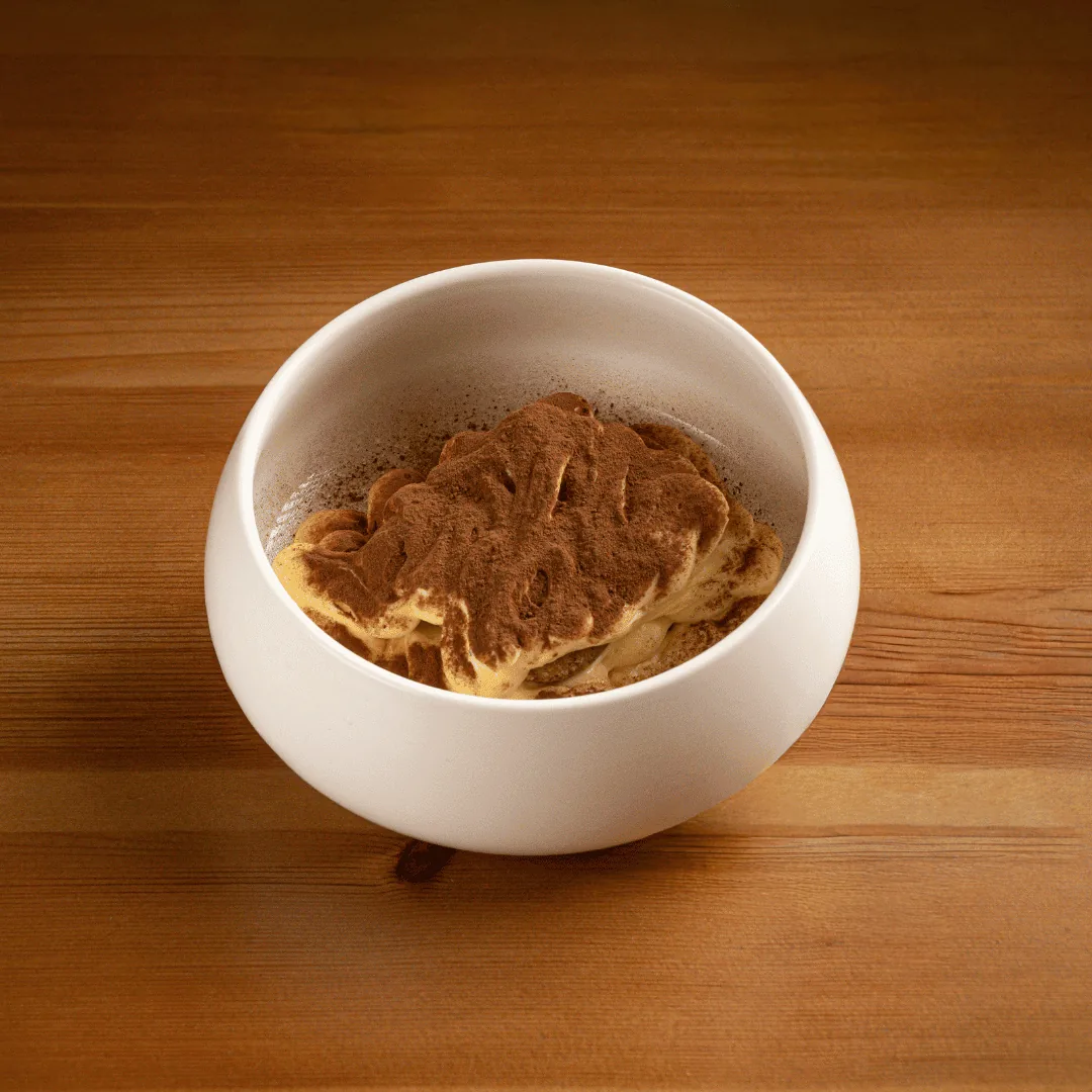 A bowl of pasta topped with a rich brown sauce