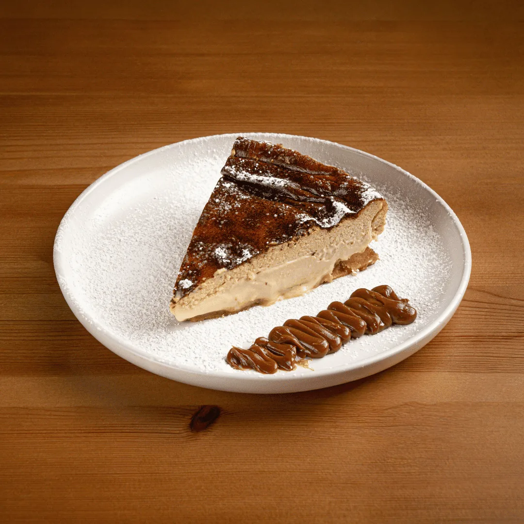 A slice of layered cake drizzled with caramel sauce