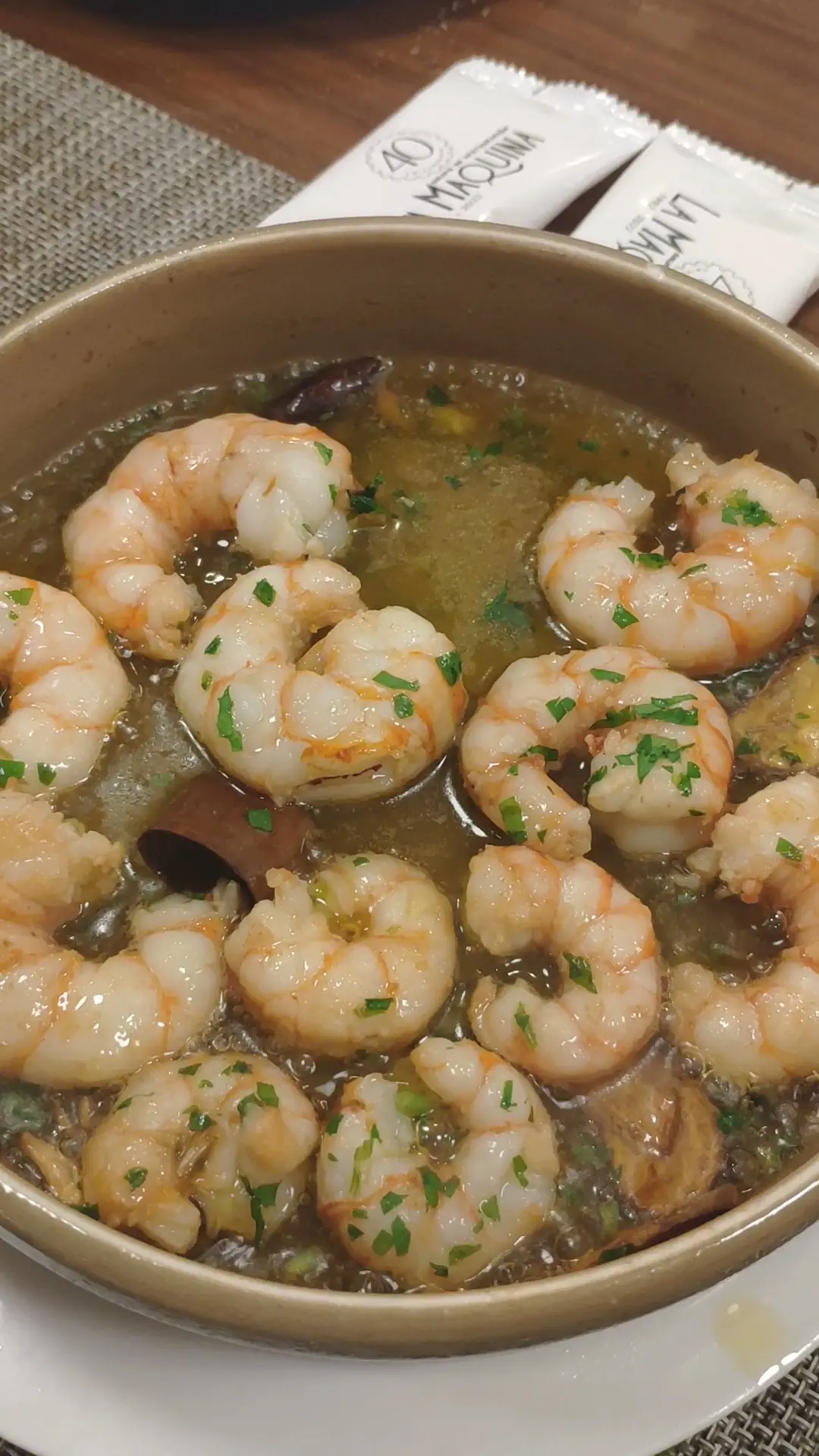 Shrimp cooked in garlic and olive oil in a clay dish.