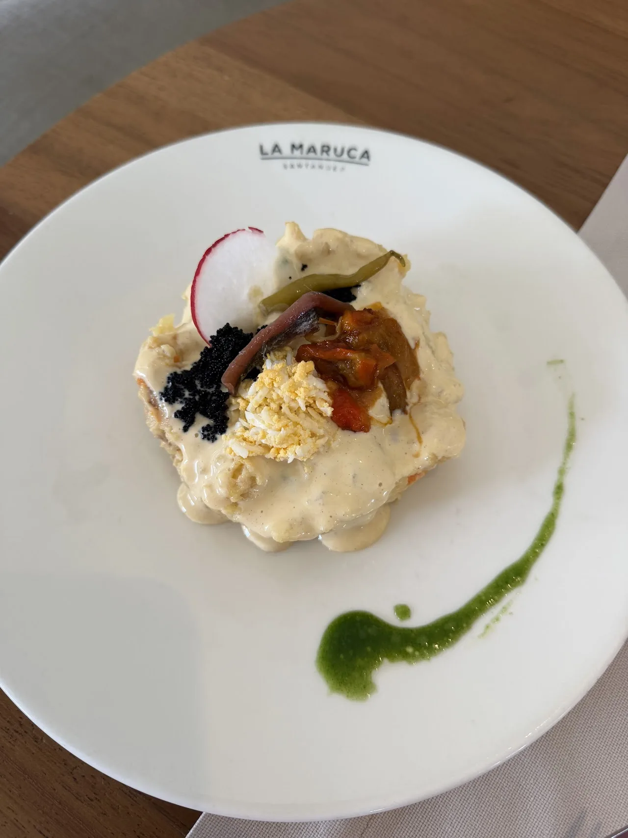 A plated appetizer with a creamy sauce and radish garnish
