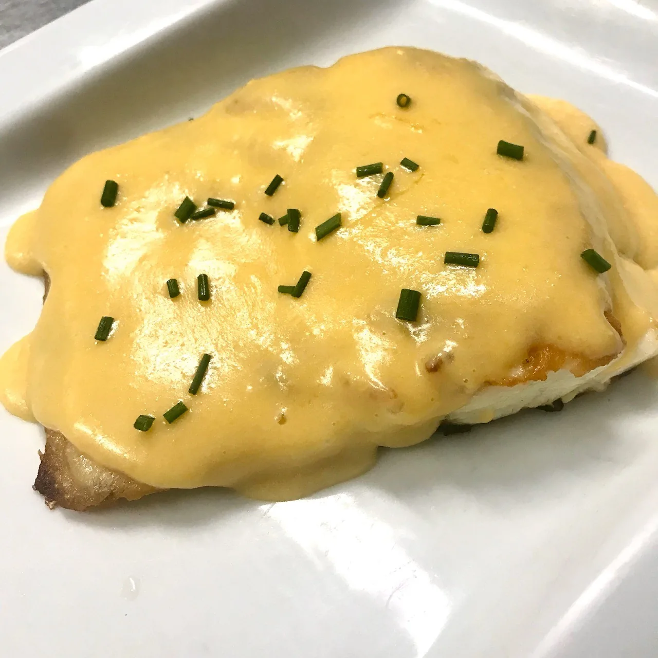 A golden gratinated dish topped with chopped chives