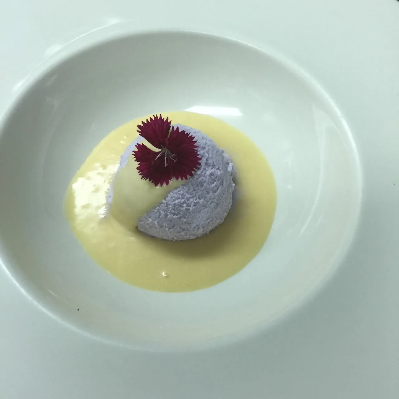 A panna cotta dessert garnished with an edible flower