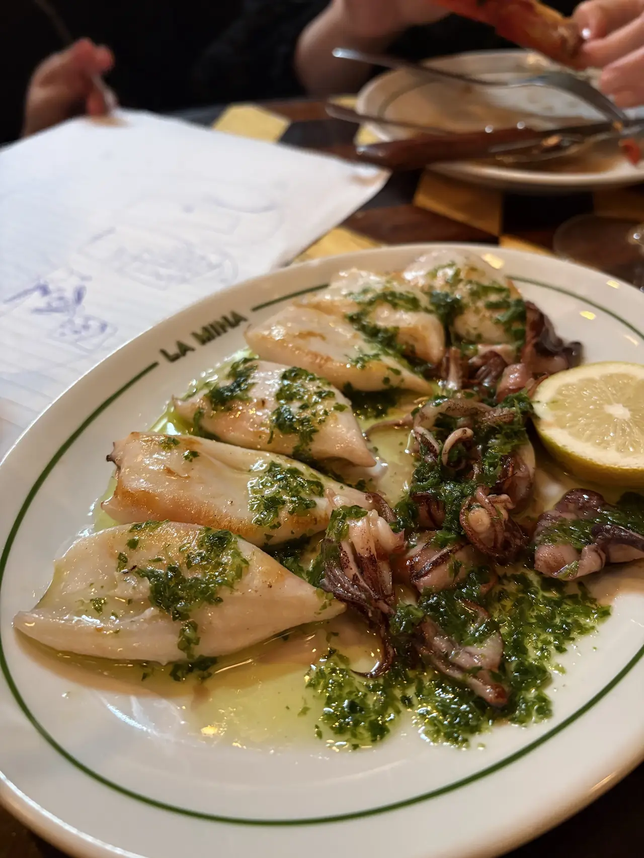 Grilled squid with parsley-garlic sauce and lemon on a La Mina plate