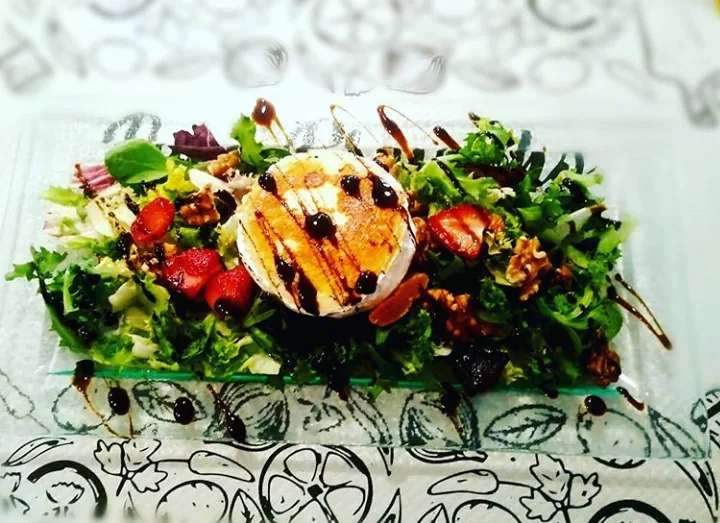 A salad with grilled goat cheese, walnuts and berries