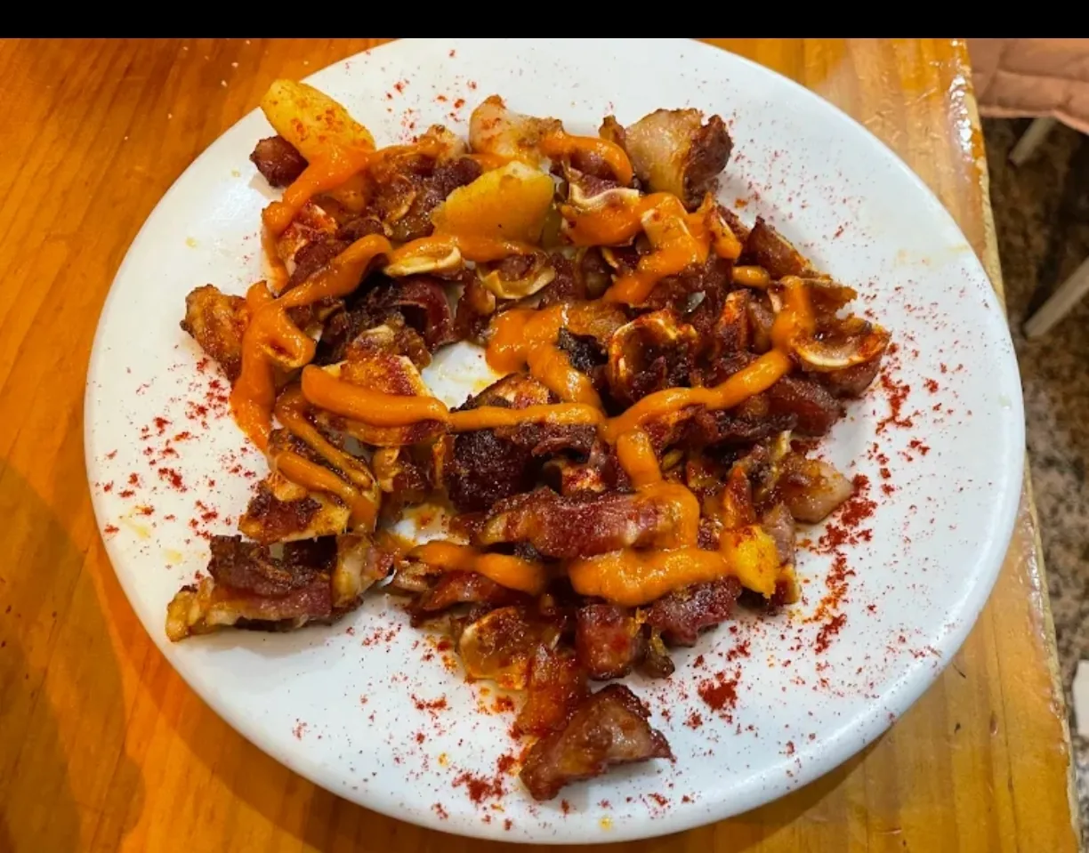A plate of grilled pig ear pieces with paprika