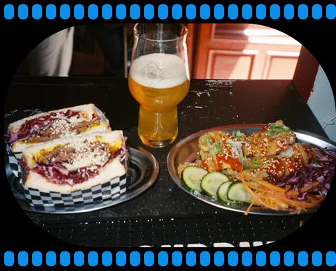 Two sandwiches and a glass of beer served on a table