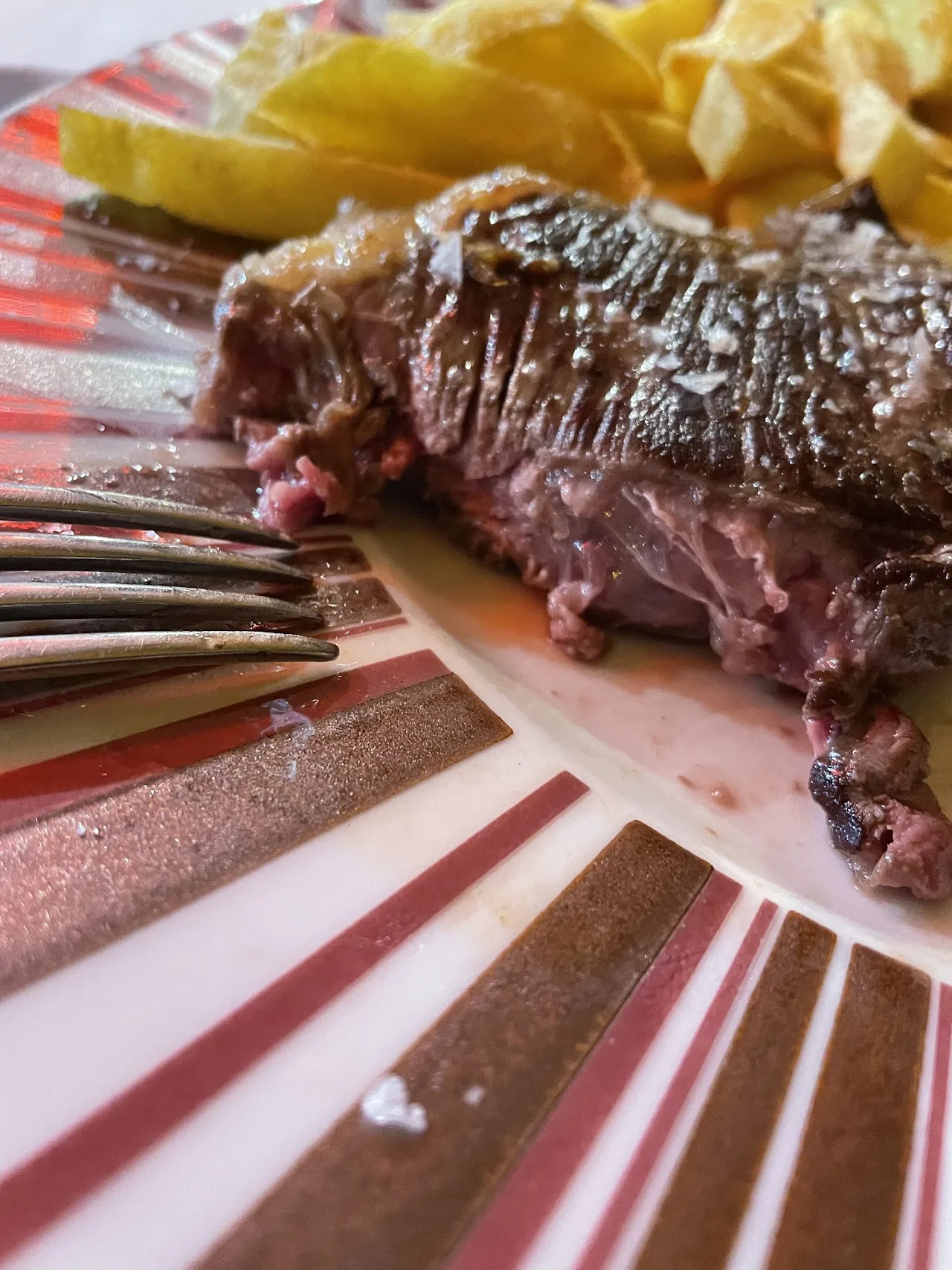 A rack of grilled ribs with lemon wedges on a plate