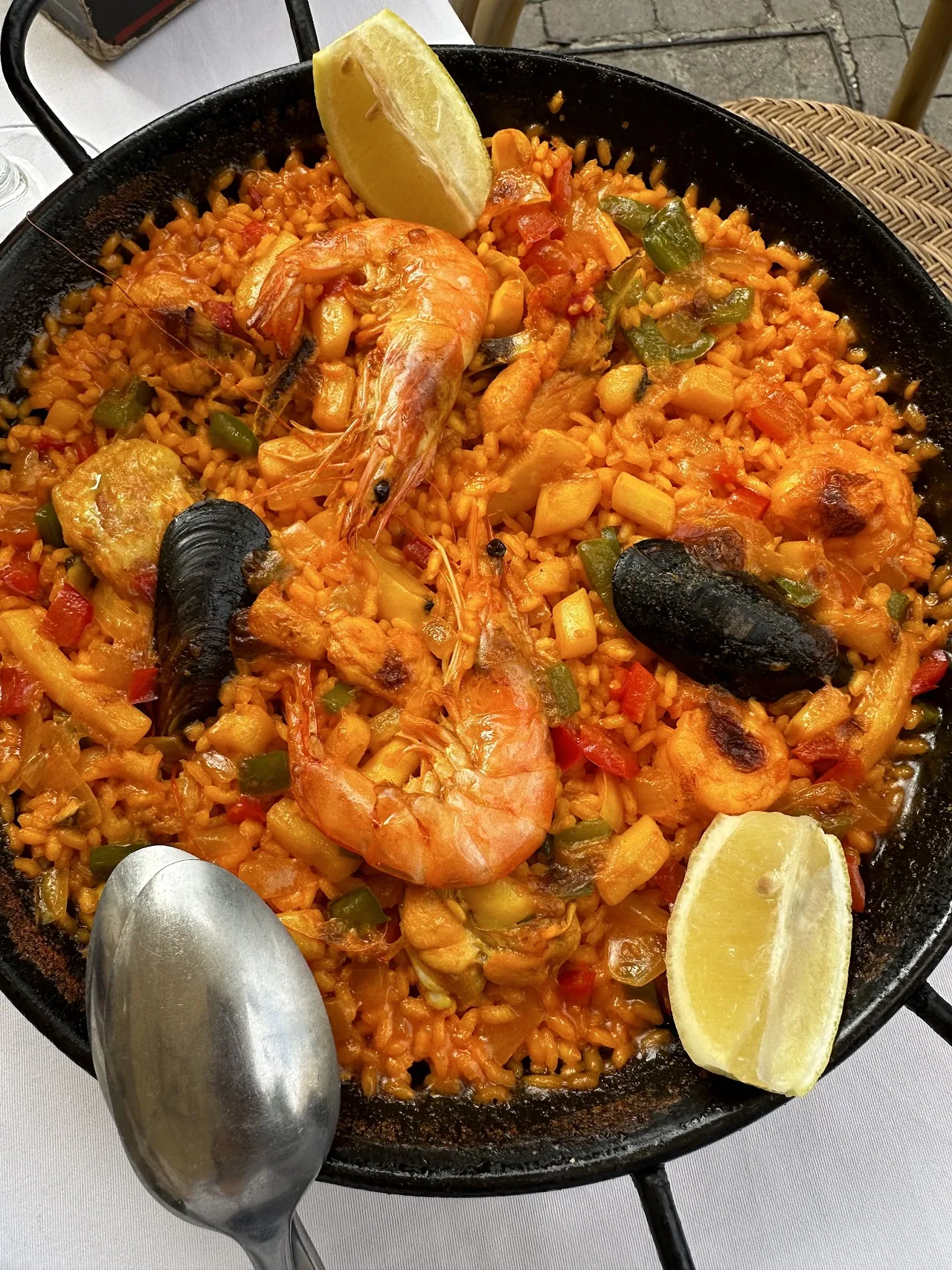 A seafood paella with shrimp, mussels and lemon in a pan