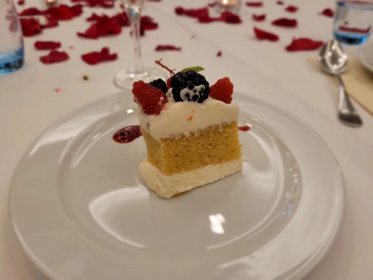 A small layered dessert topped with berries and chocolate garnish