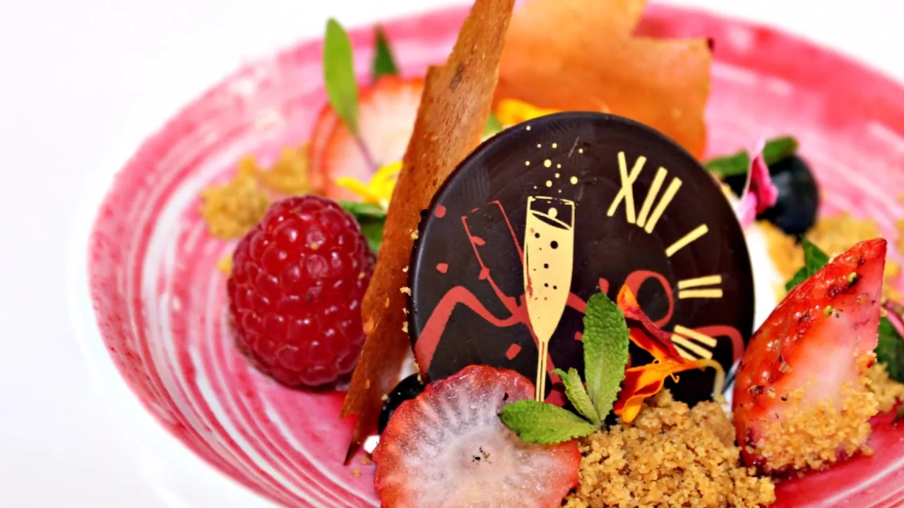 An elaborate plated dessert with strawberries and chocolate decoration