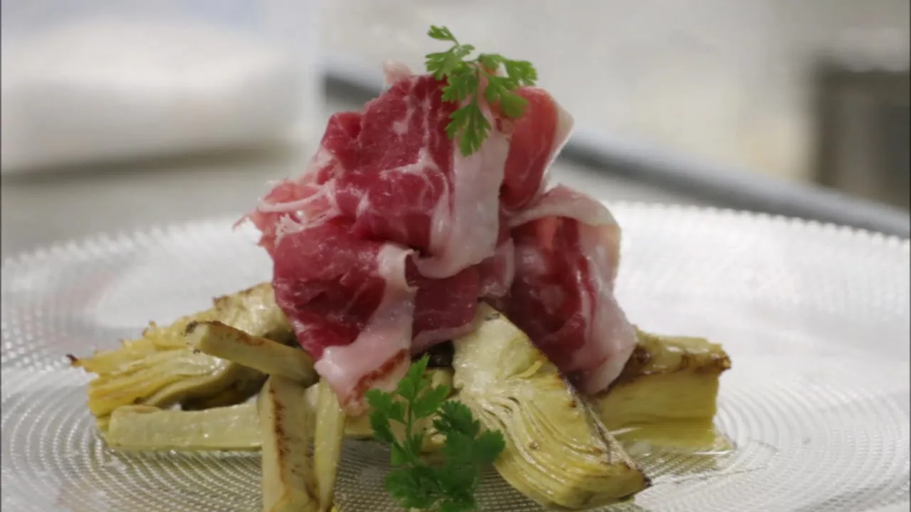 Rolled beef carpaccio with greens on a plate