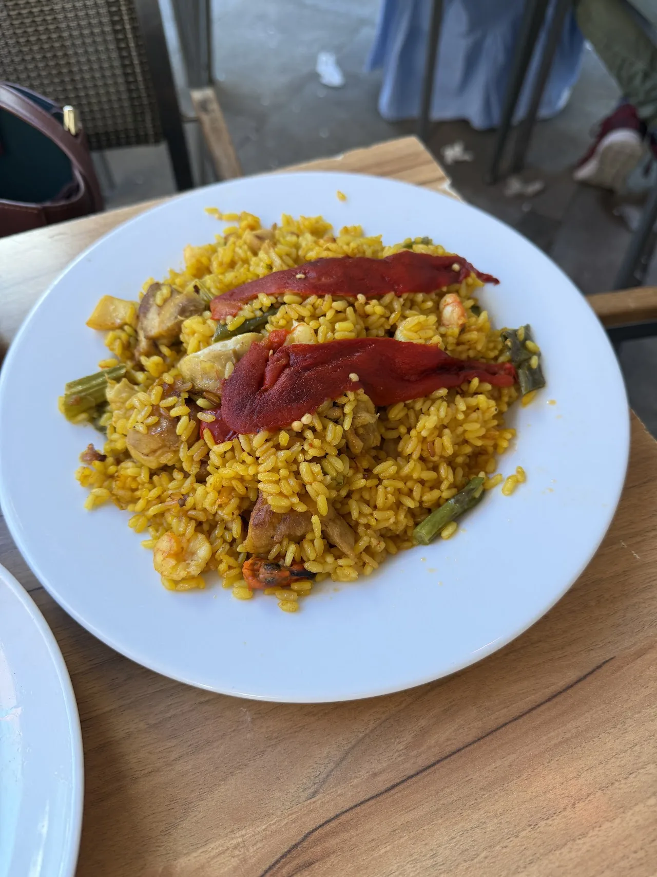 A plate of yellow rice topped with strips of jamón