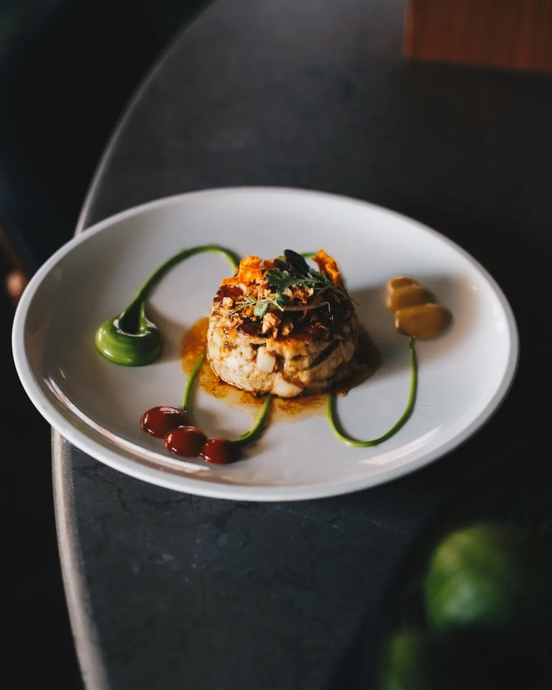 A small plated dish with sauces on a white plate