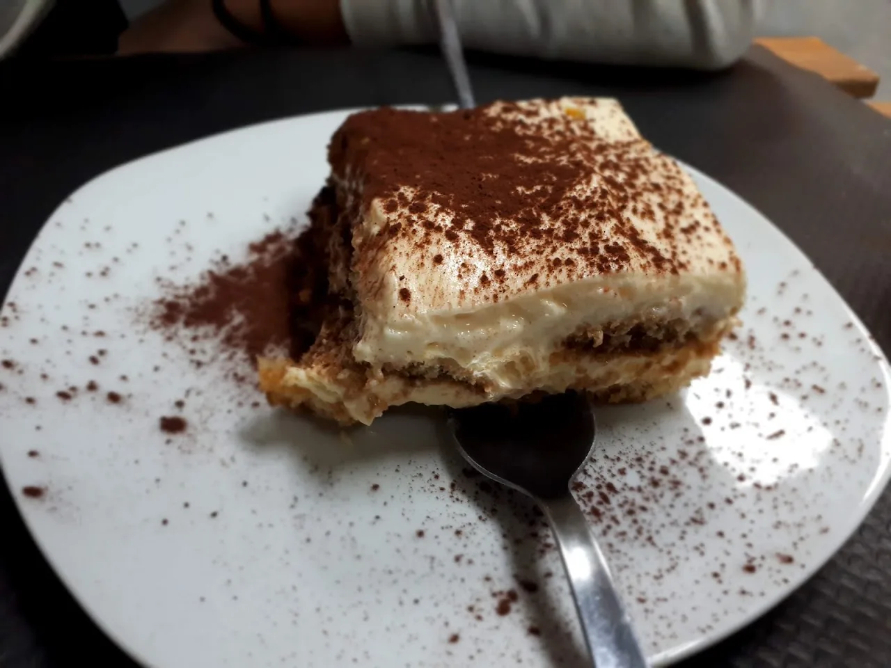 A slice of tiramisu dusted with cocoa powder