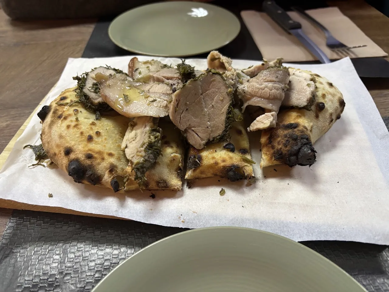 Rolled porchetta slices on parchment paper