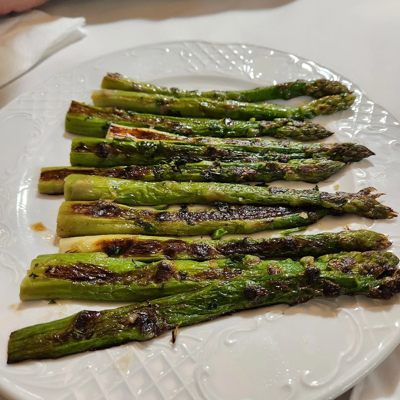 Grilled green asparagus on a white plate