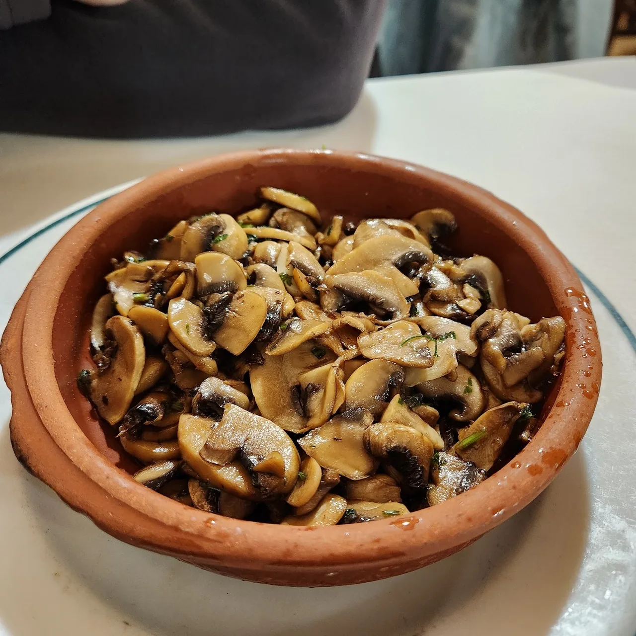 A terracotta dish of sliced mushrooms