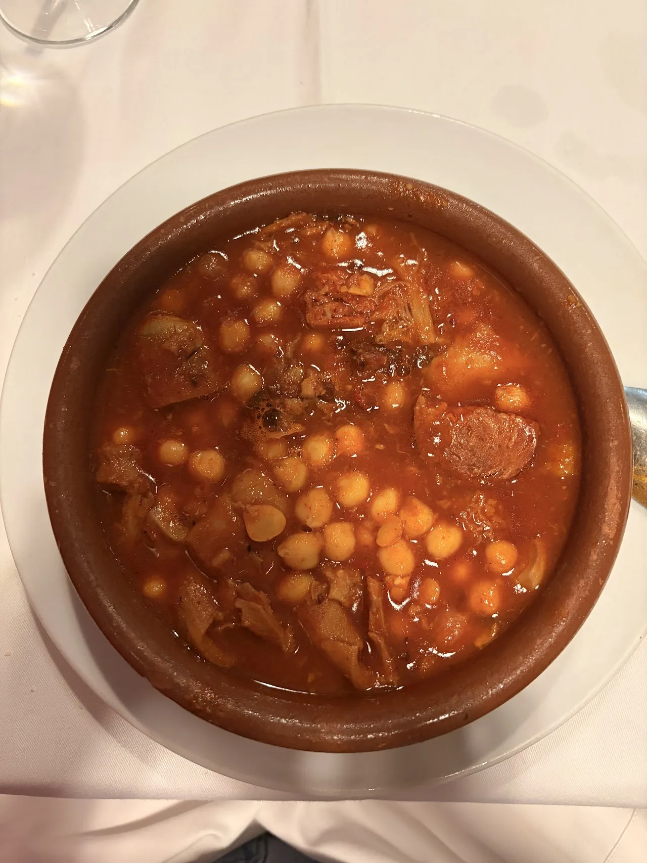 A clay bowl of chickpea and chorizo stew