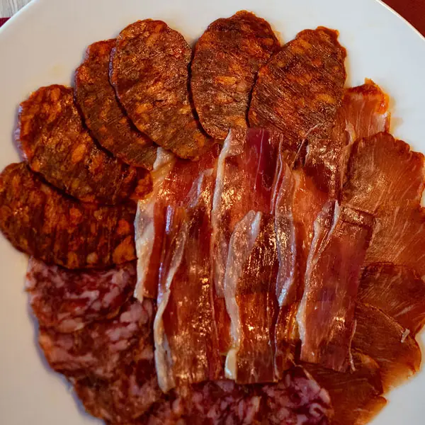 A plate of Iberian cured meats: sliced ham, chorizo and salchichón