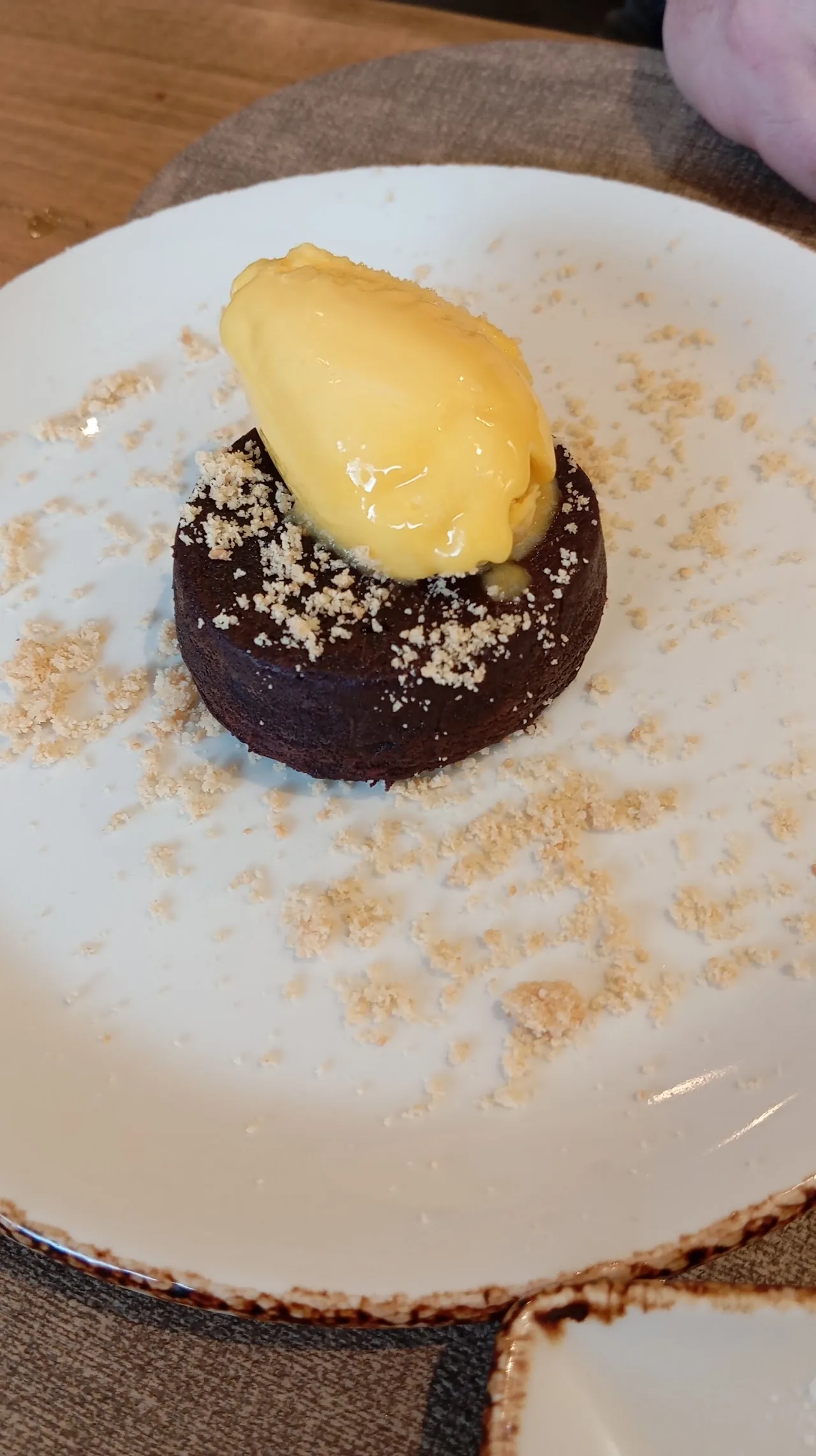 A chocolate dessert with a scoop of sorbet