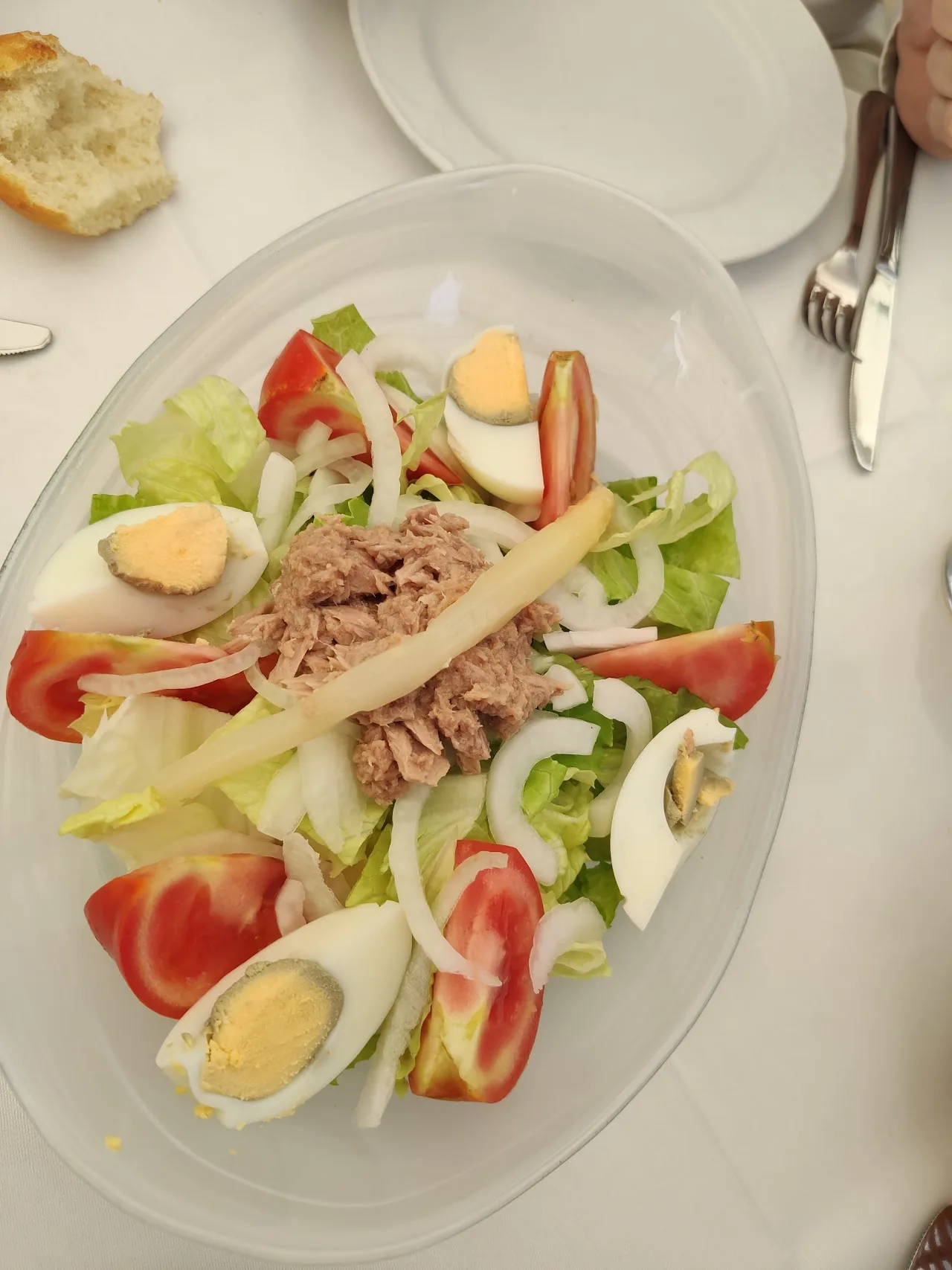 A mixed salad with tuna, boiled egg, tomato, and asparagus