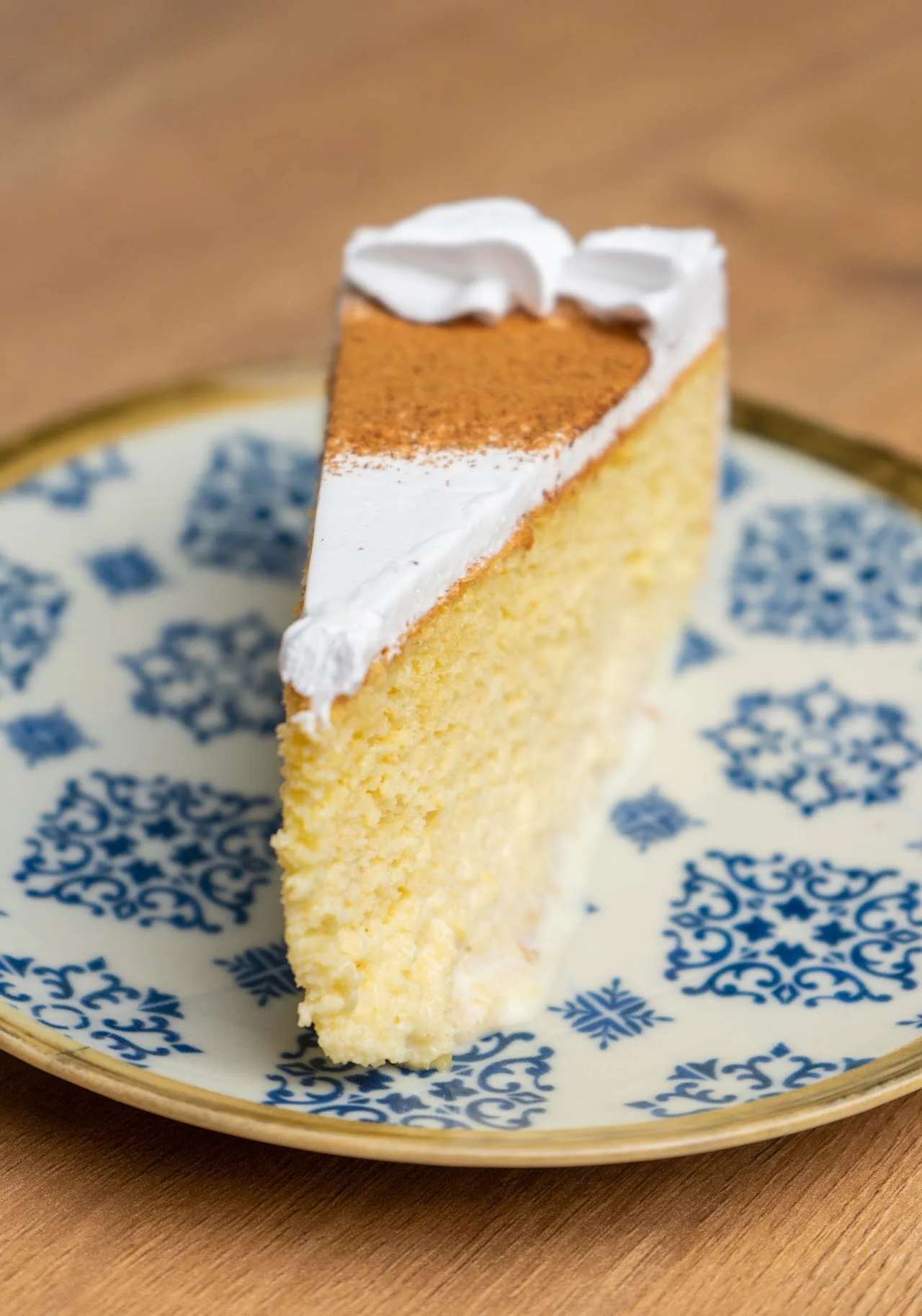 A slice of frosted cake on a patterned plate