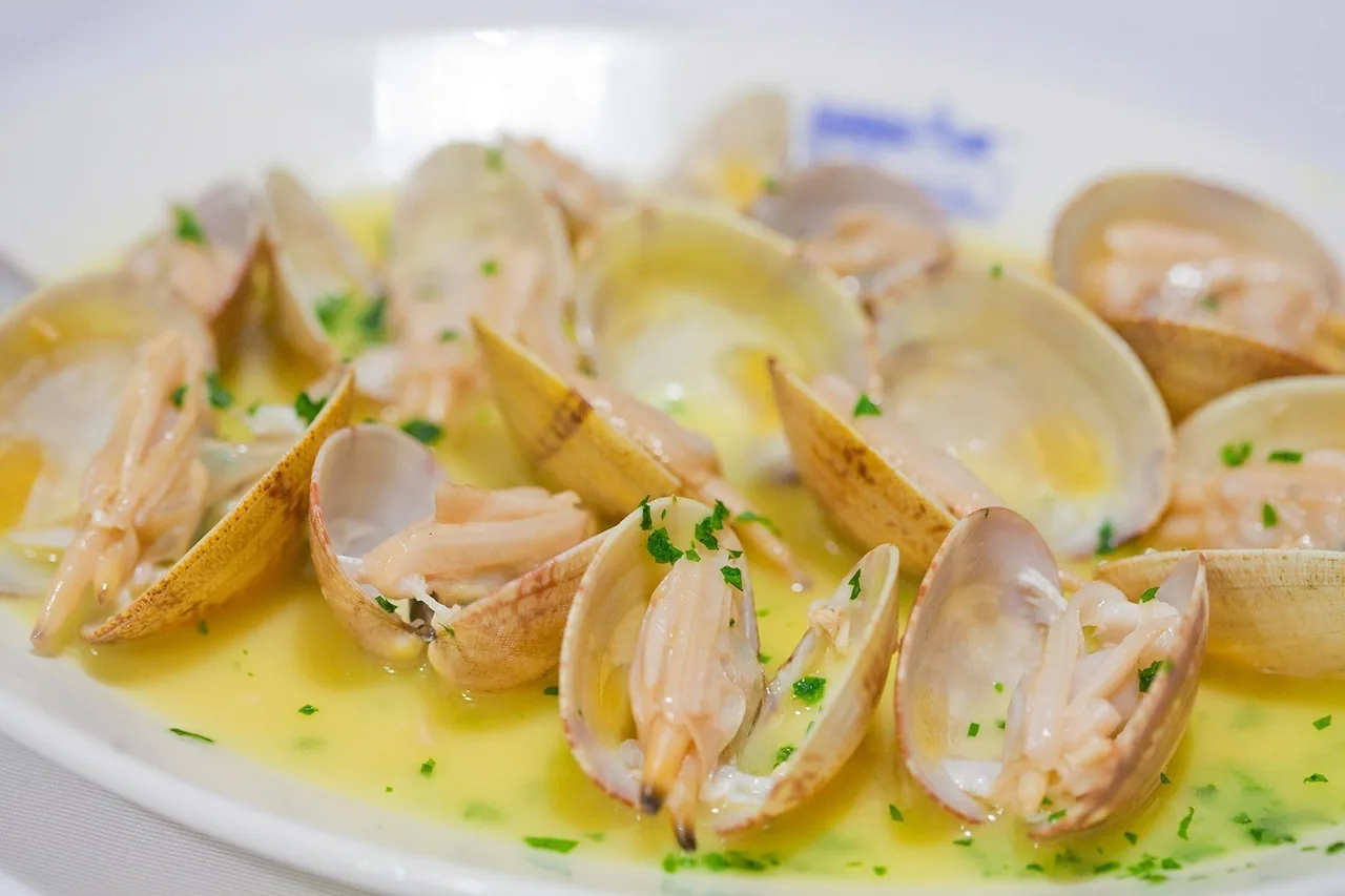 A dish of clams in a light green sauce