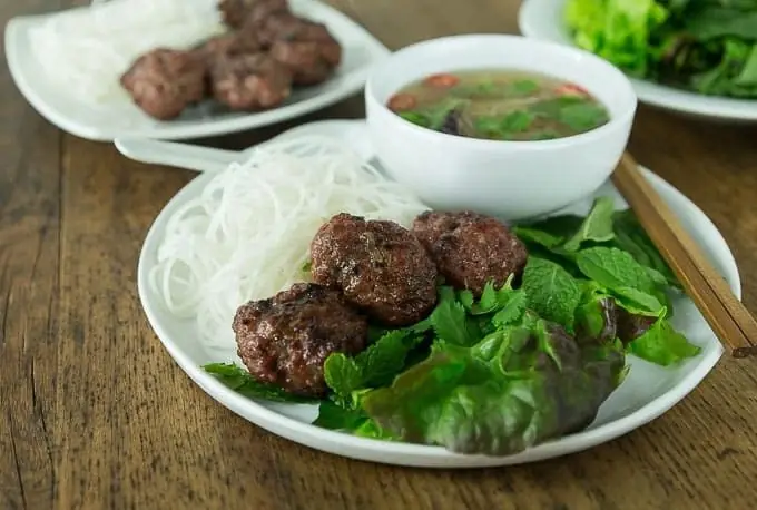 Grilled pork meatballs served with rice vermicelli, fresh herbs and a small bowl of dipping broth, La Vietnamita