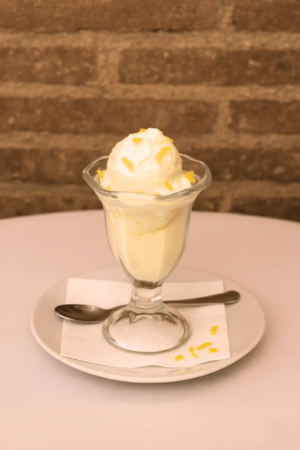Scoop of vanilla ice cream with citrus zest served in a glass sundae dish, La Yaya Amelia