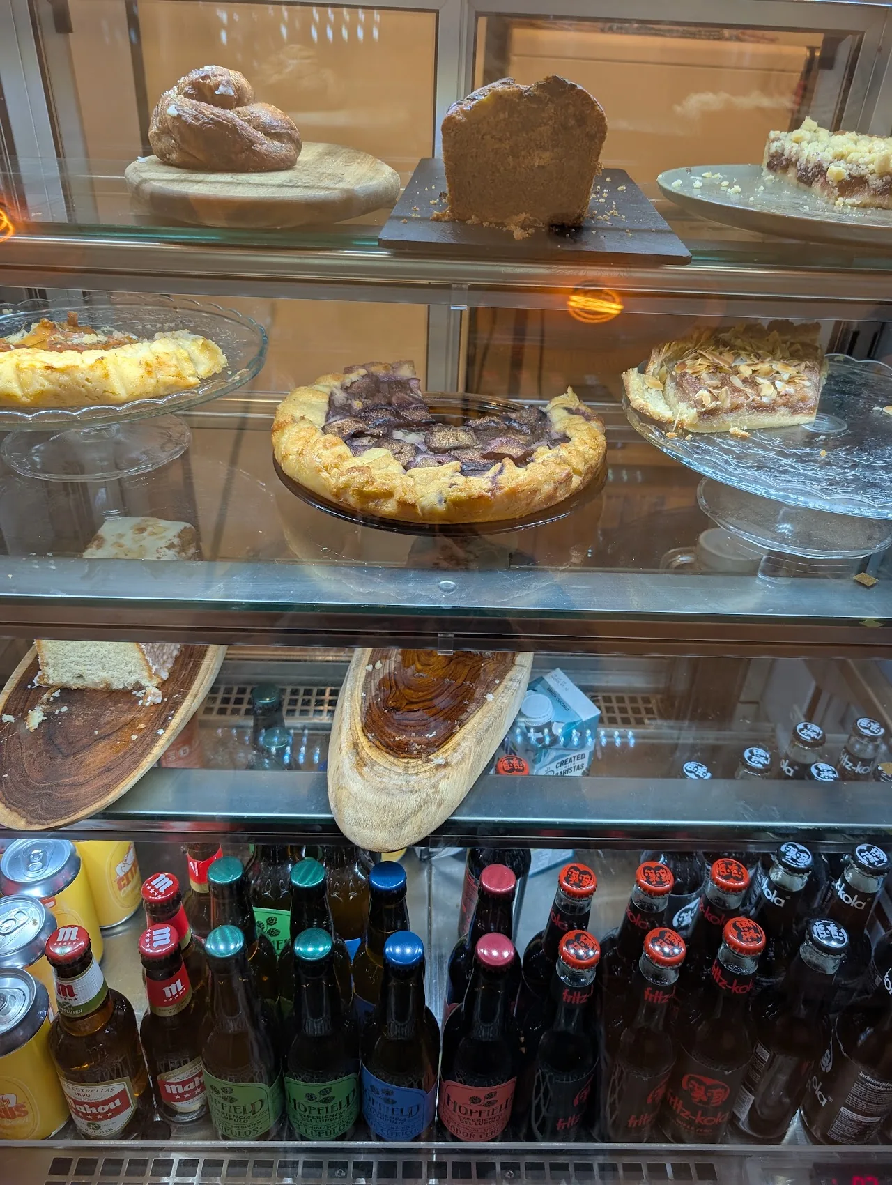 A glass display case of pastries and cakes