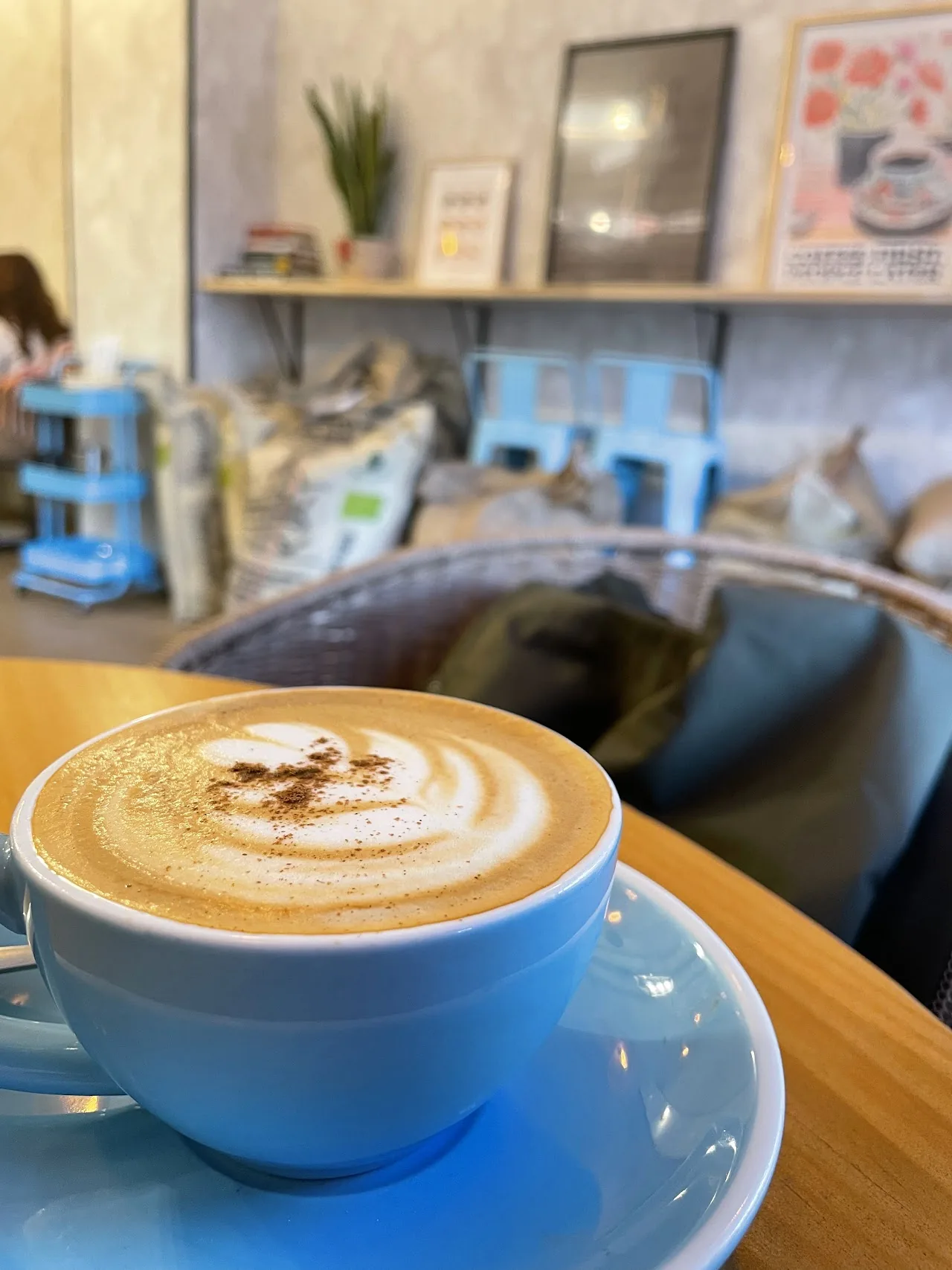 A latte with heart-pattern latte art in a blue cup