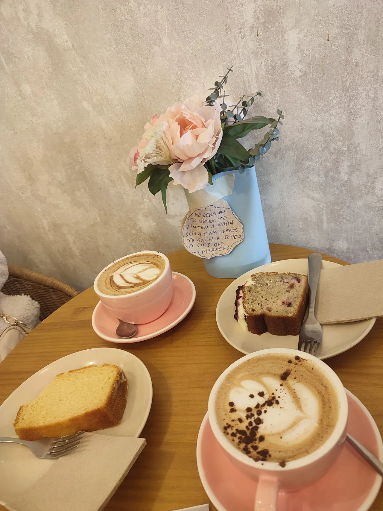 Two lattes with slices of cake on a table