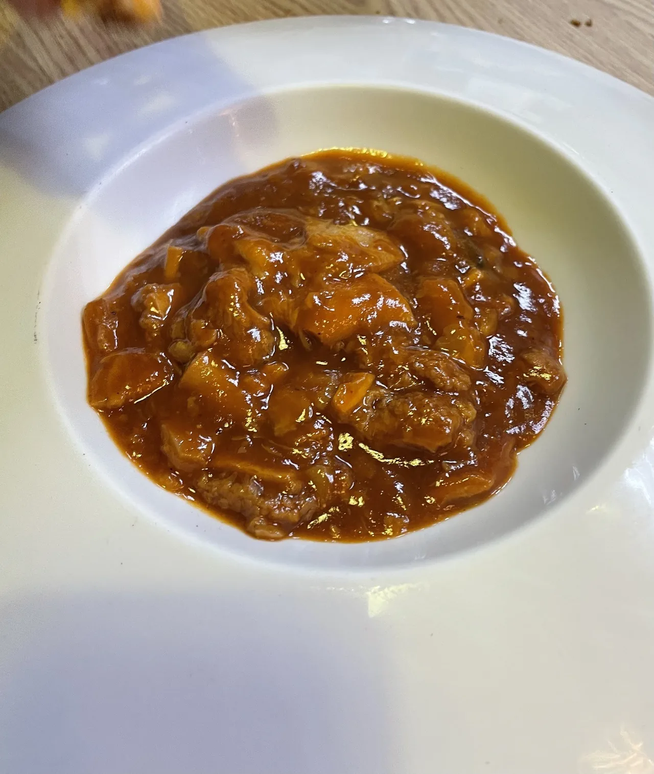 A white bowl of a dark brown stew