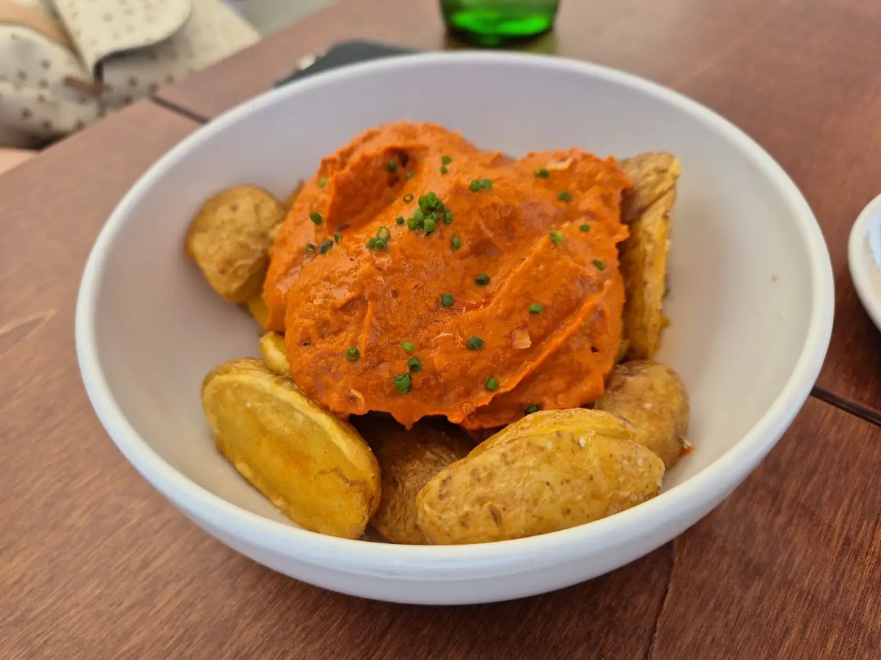 Patatas bravas topped with spicy tomato sauce in a bowl