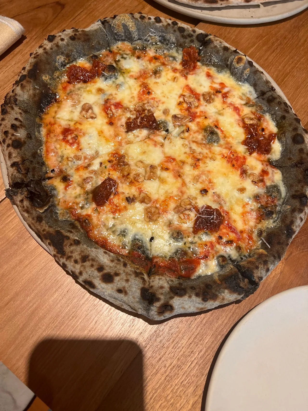 A cheese pizza on a dark pan