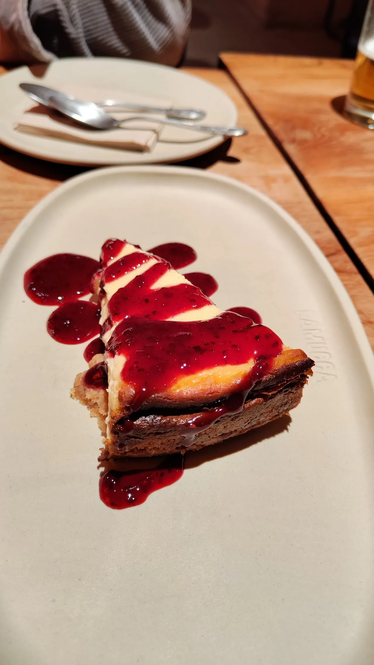 A slice of chocolate tart with a red berry sauce drizzle