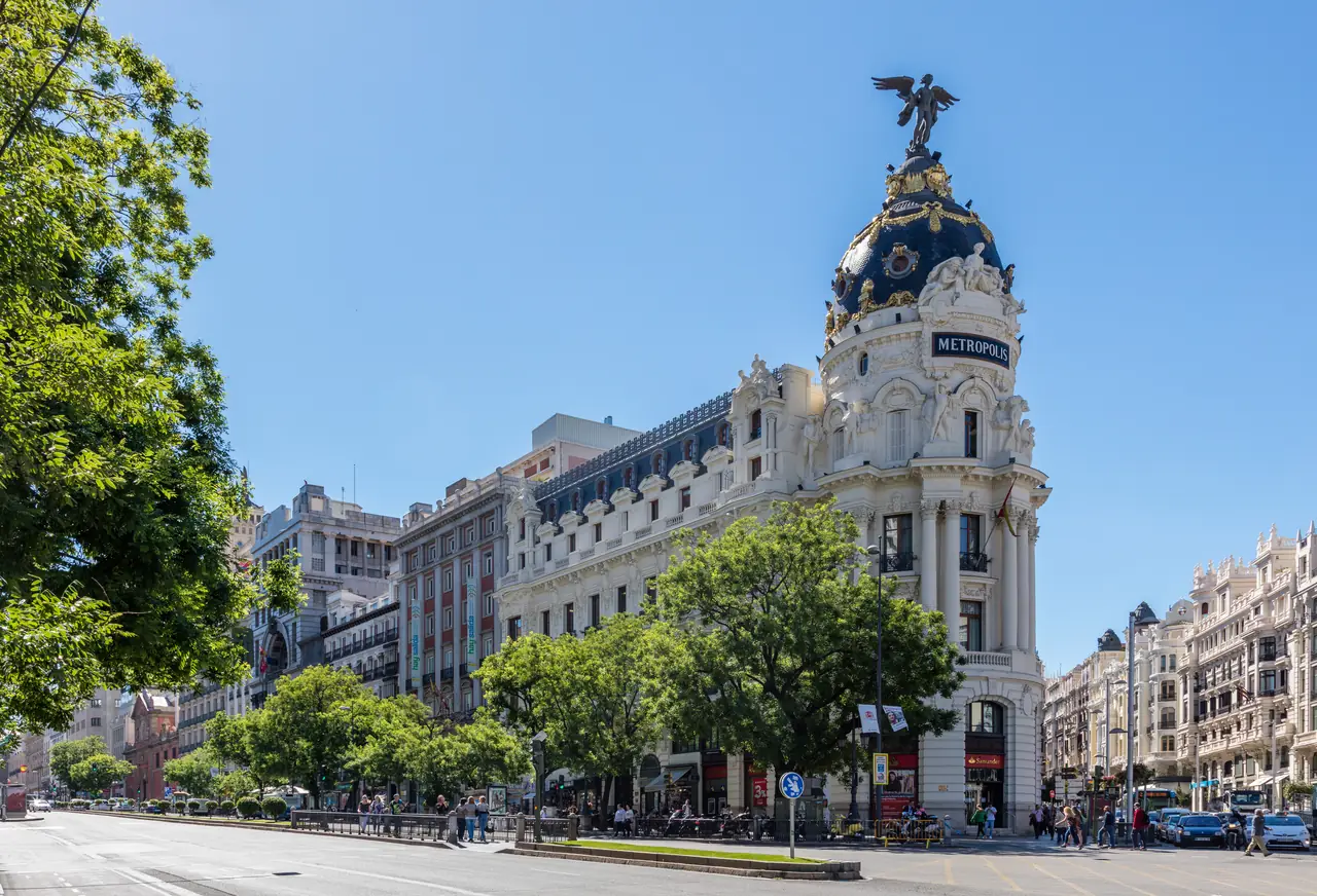 Edificio Metrópolis on Gran Vía with its winged bronze statue atop the domed corner tower, seen from the street below