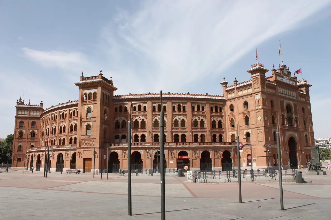 The red-brick Mudéjar facade of Plaza de Toros de Las Ventas, with its horseshoe arches and 'Plaza de Toros' signage on the tower