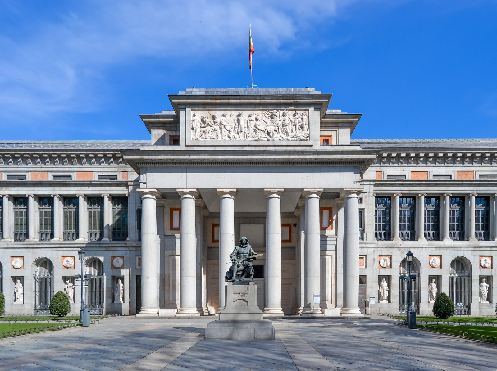 The colonnaded entrance of the Museo del Prado with the bronze statue of Velázquez on its pedestal out front